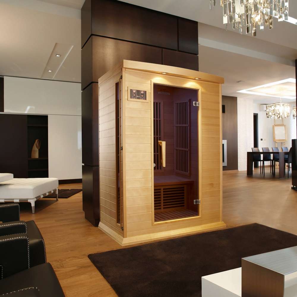 Golden Designs Maxxus Toulose 2 Person Low EMF Far Infrared Sauna stands in a modern living space with wood floors and warm lighting