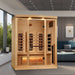 Golden Designs Reserve Edition 3 Person Full Spectrum Sauna with Himalayan Salt Bar stands in a modern living room beside a gray sofa, framed art and large windows