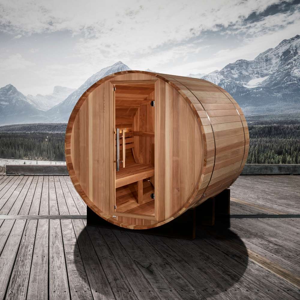 Golden Designs St. Moritz 2 Person Barrel Traditional Sauna sits on a wood deck with snowy mountains and a lake in the background