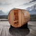Golden Designs St. Moritz 2 Person Barrel Traditional Sauna sits on a wood deck with snowy mountains and a lake in the background