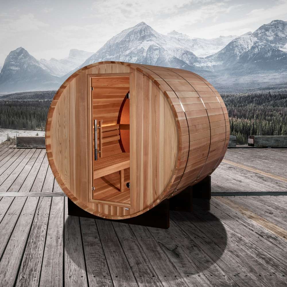 Golden Designs Zurich 4 Person Barrel with Bronze Privacy View Traditional Sauna on a wooden deck with snowy mountains and a cloudy sky behind it