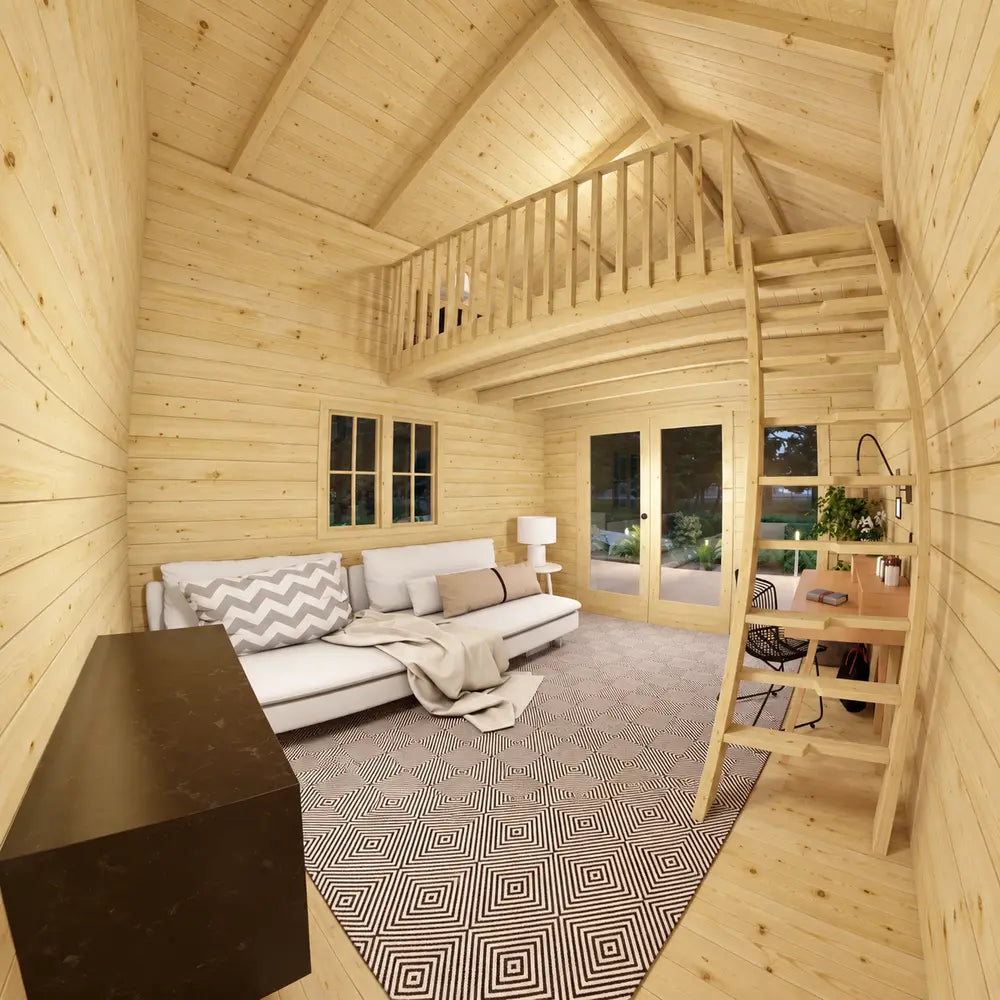 GrandView 150 garden room interior with a white sectional couch, patterned rug, writing desk, wooden ladder and upper sleeping loft.