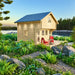 Grand Loft 107 Deluxe DD wooden cabin beside a calm lake, surrounded by rocks, ferns and trees, with red chairs on the porch.