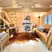 Grand Loft 107 Deluxe DD main floor with a leather sofa, cowhide rug, dining area, fireplace and ladder stairs leading to the loft.