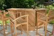 Group of Westminster Teak Somerset Teak Bar Stools surrounds a wooden outdoor bar table holding wine glasses and a bottle
