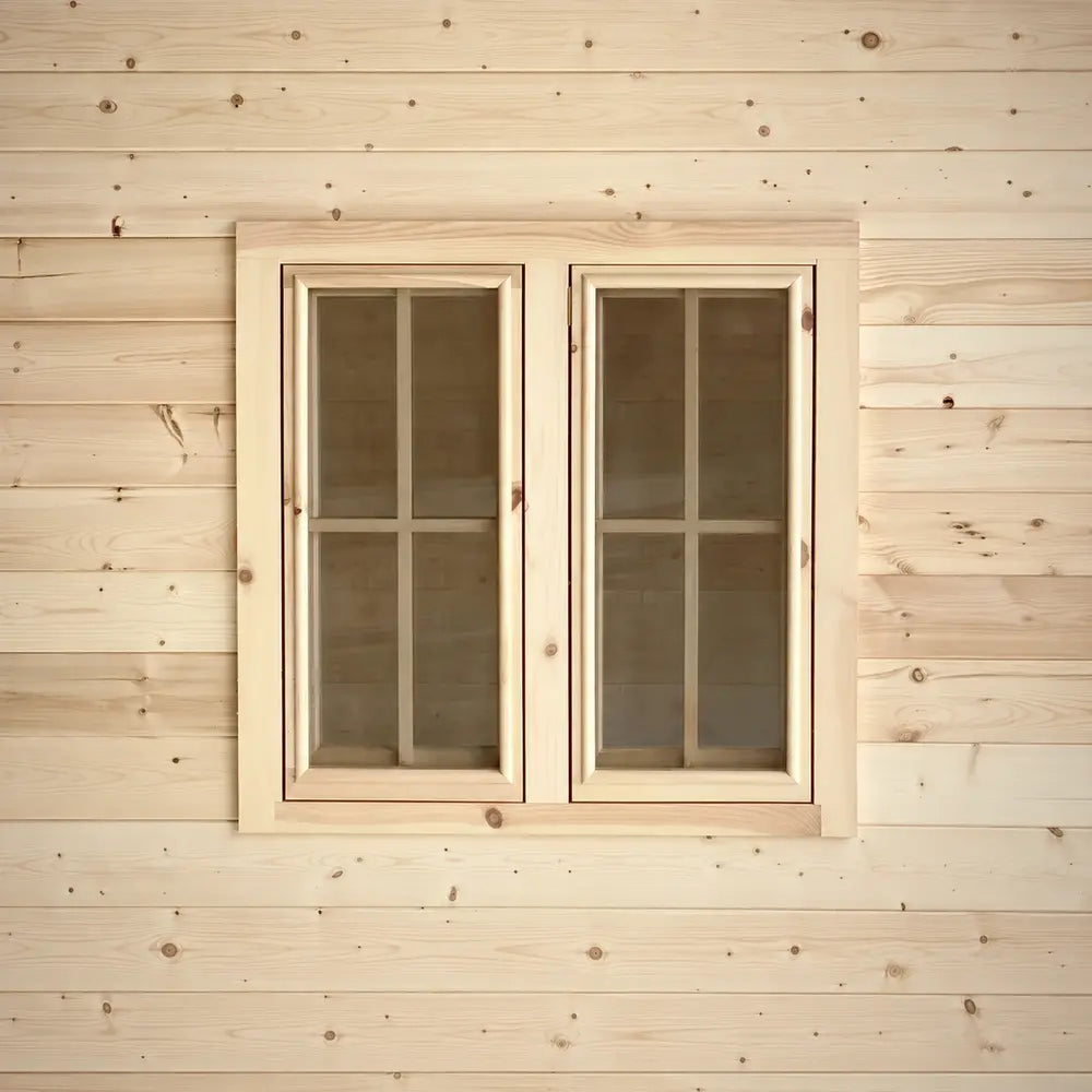 Pair of rectangular wooden windows with four-pane grids set into the pale wood exterior of the Harvest Grand Bungalow.