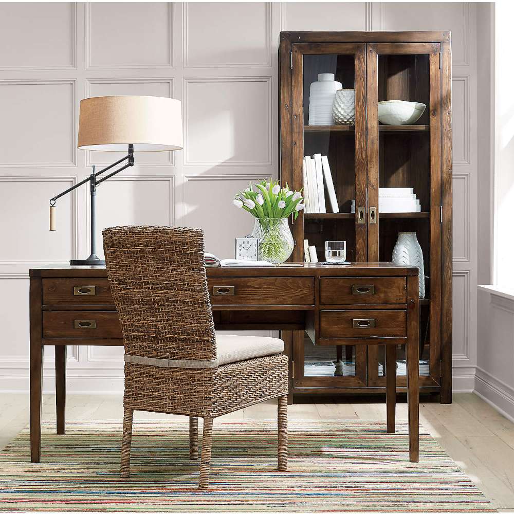 Home office featuring Crate & Barrel Morris 36" Chocolate Brown Wood and Glass Bookcase Cabinet behind a wooden desk