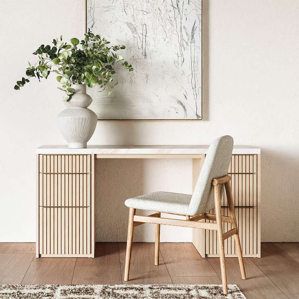 Home office setup featuring Crate & Barrel Batten 62" White Oak Wood Console Desk with White Marble Top and upholstered chair