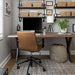 Home office setup featuring Crate & Barrel Graham Brown Office Chair at a wood desk with wall shelving and storage baskets