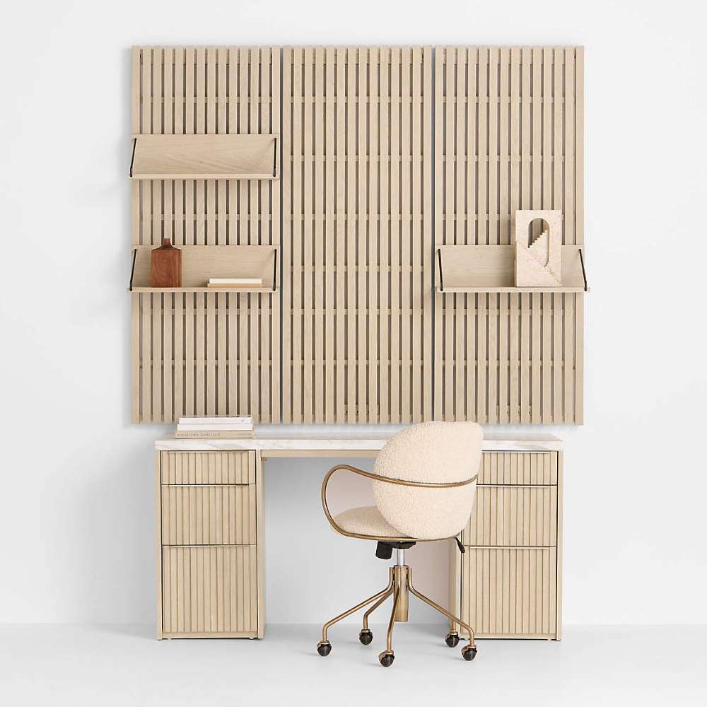 Home office setup with Crate & Barrel Batten 62" White Oak Wood Desk with White Marble Top and Panel Set with 3 Reversible Shelves, paired with a swivel chair and decorative accents