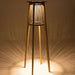 Illuminated Westminster Teak Luna Standing Lamp casts a warm, ambient glow downward, creating a soft patterned light on the floor beneath it