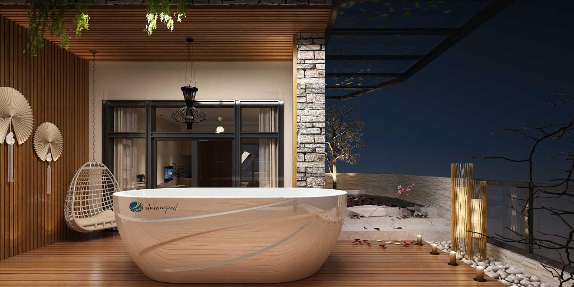 In a cozy, warmly lit outdoor setting, a Dreampod Ice Bath with Chiller is positioned on a wooden deck with decorative plants and soft lighting