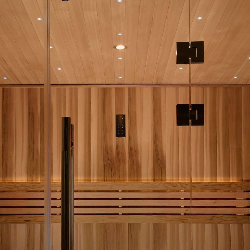 Inside Golden Designs Copenhagen 3 Person Traditional Sauna, tiny star lights dot the cedar ceiling above a black door handle and softly lit backrest boards