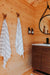 Inside Sawmill Structures Loo Loo House Garden Room striped towels hang neatly on antler hooks next to a modern wooden vanity with soap dispensers