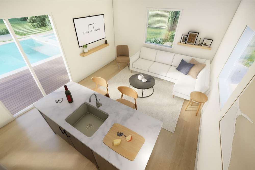 Inside Sawmill Structures The Banff Garden Suites, a sleek kitchen island overlooks a bright living area with modern seating and poolside views
