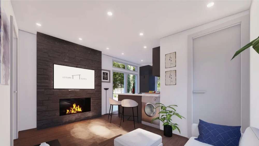Inside Sawmill Structures The Muskoka Garden Suites, the living room includes a stone fireplace, mounted TV, and an open concept layout with a kitchen bar