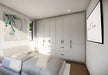 Inside Sawmill Structures The Tremblant Garden Suites a cozy white bedroom features a large bed, full-wall cabinetry, abstract art, and a wall-mounted TV