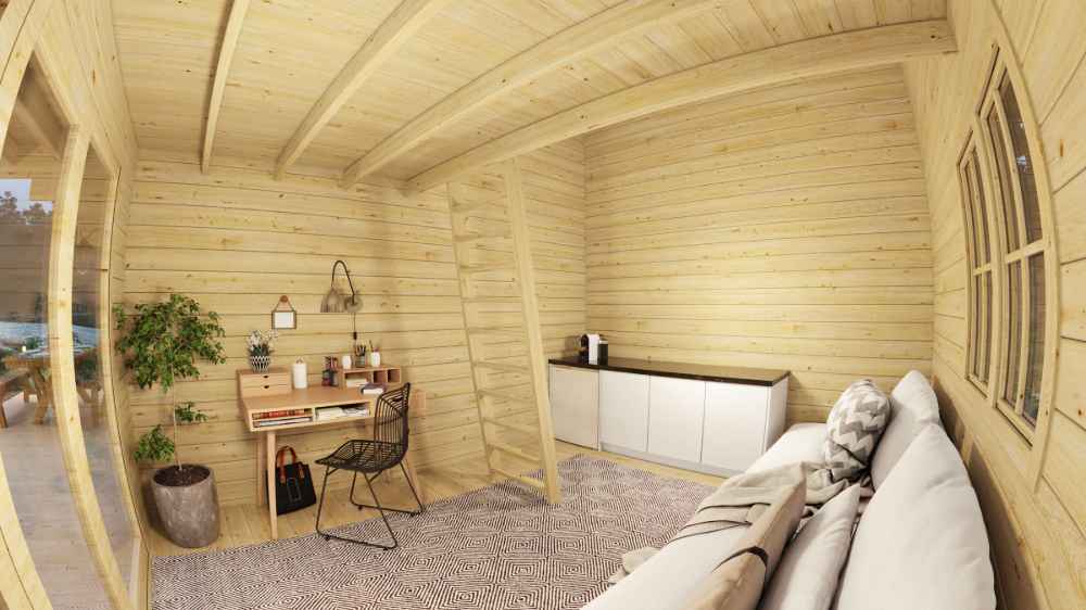 Inside the Sawmill Structures GrandView 150 70MM Garden Room, there's a small home office with a desk, black chair, potted plants, and light wood walls
