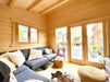 Inside the Sawmill Structures The Versa 107 70MM Garden Room, cozy seating with plush pillows and poufs faces the bright glass doors and garden view