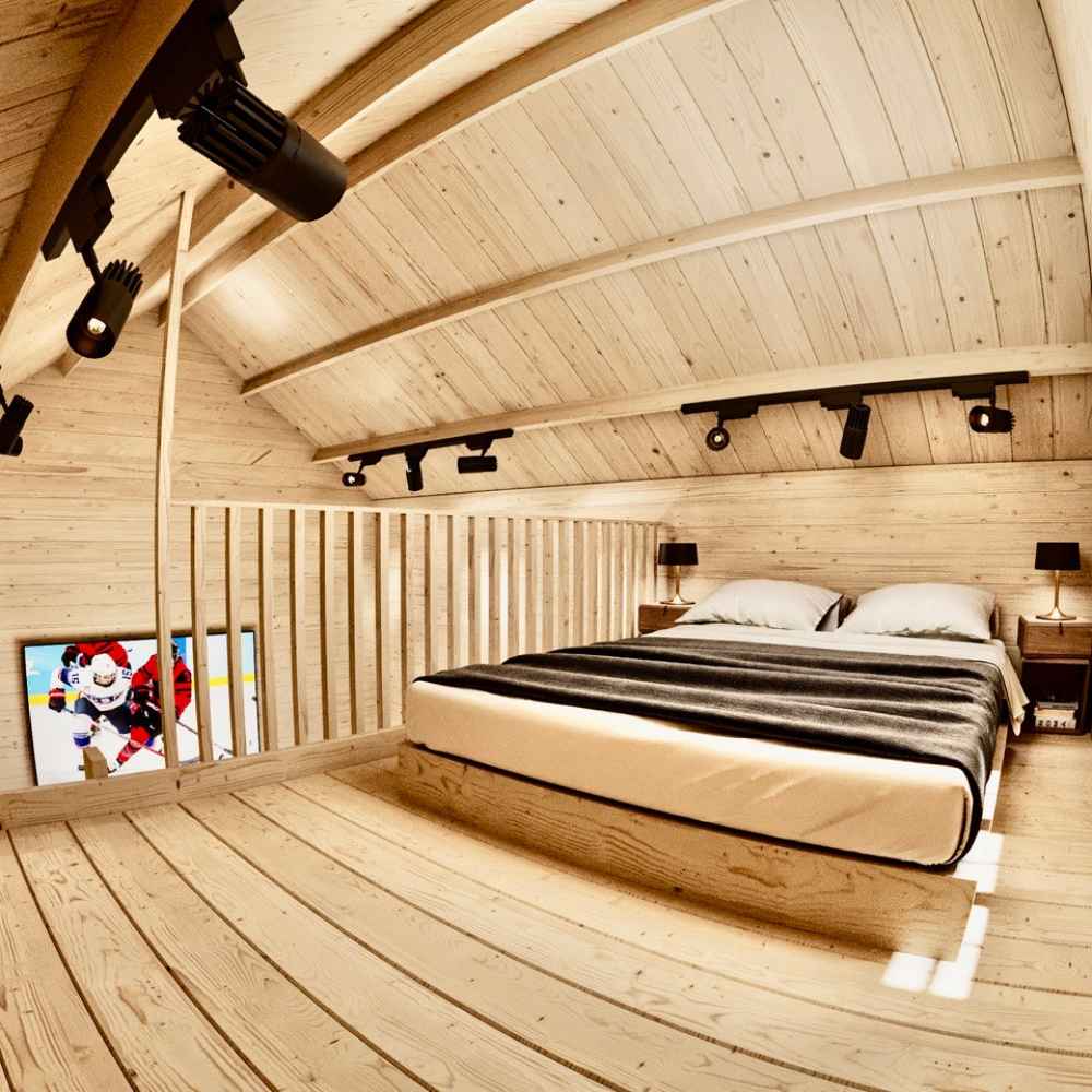 Inside the loft of the Sawmill Structures Grand Loft 107 Deluxe DD Garden Room, a clean and modern bedroom features a low platform bed and black track lighting on the wood ceiling