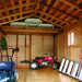 Inside the Outdoor Living Today 8×12 Space Master Storage Shed, various tools and equipment are neatly stored with chairs stacked in the rafters
