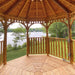 Interior view of Outdoor Living Today Western Red Cedar Octagon Bayside Gazebo shows a wooden floor and open sides overlooking a calm lakeside