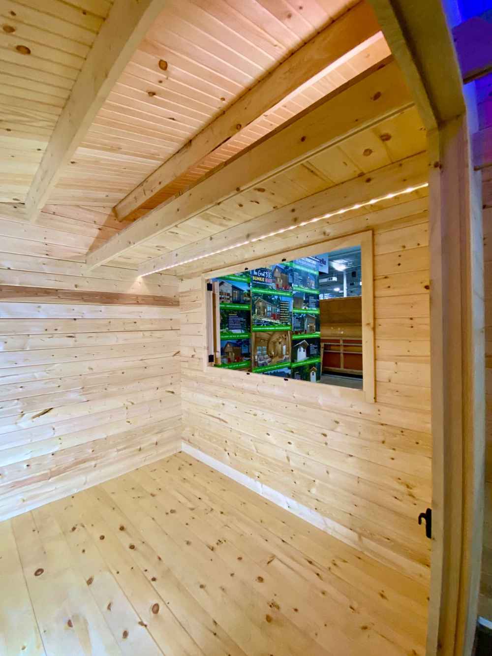 Interior view of the all-wooden Sawmill Structures The Lakeside Versa Cabana 67 Garden Room shows unfinished pine walls and ceiling beams
