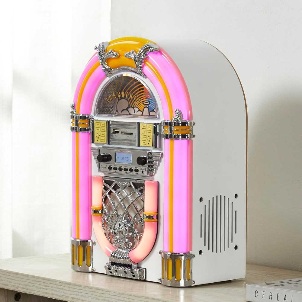 In this image, the Arkrocket Athena Mini Jukebox Tabletop CD Player Bluetooth Speaker (PinkWhite) is displayed on a light-colored wooden surface