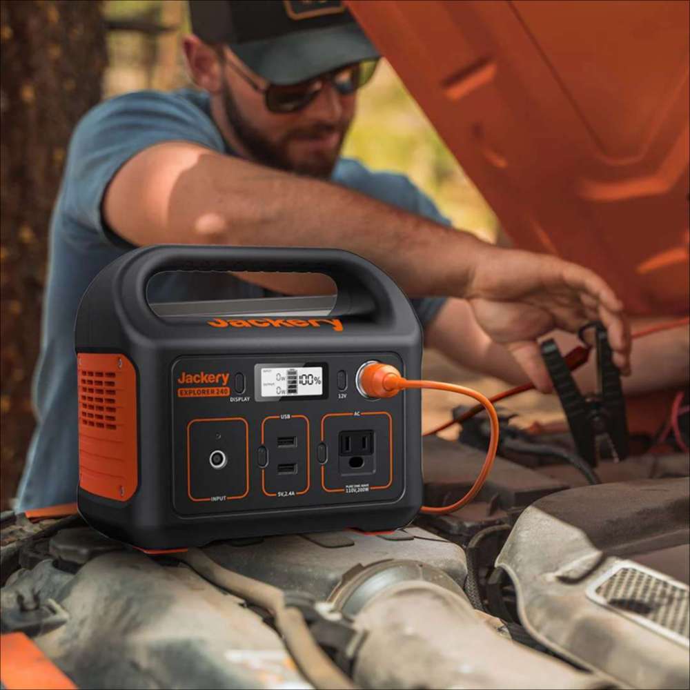 Jackery 12V Automobile Battery Charging Cable connected to a Jackery portable power station to help charge a vehicle battery under an open car hood