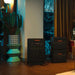 Jackery Battery Pack 5000 Plus connected to a home backup power station beside stacked battery packs in a living room during a nighttime power setup