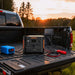 Jackery DC-DC Alternator Charger mounted in a pickup truck bed and connected to a Jackery portable power station during outdoor charging