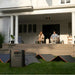 Jackery HomePower 3600 Plus Portable Power Station connected to folding solar panels on a lawn outside a home for solar charging