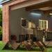 Jackery Solar Generator Explorer 5000 Plus + SolarSaga 500X x 2 installed in a garage and connected to foldable solar panels spread across a lawn