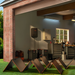 Jackery Solar Generator Explorer 5000 Plus + SolarSaga 500X x 2 installed in a garage and connected to foldable solar panels spread across a lawn
