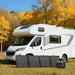 Jackery SolarSaga 100W Air Solar Panel paired with a portable power station in front of an RV parked outdoors