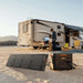 Jackery SolarSaga 40 Air Solar Panel powers a portable power station beside an RV at a sunny campsite
