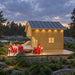 Jumbo Grand Loft 130 SD cabin at dusk with illuminated wood siding, modern deck lighting and bright red Adirondack chairs.