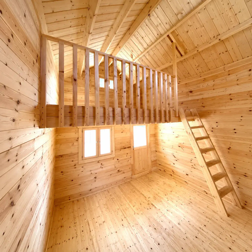Bright empty Jumbo Grand Loft 130 SD interior with tall pine walls, a wooden ladder, upper loft railing and high sloped ceiling.