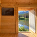Open doorway inside the Jumbo Grand Loft 130 SD revealing a sunlit lake, pine forest and mountain landscape.