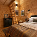 Rustic Jumbo Grand Loft 130 SD bedroom with warm patterned blankets, pine walls and a wooden ladder leading to the loft.