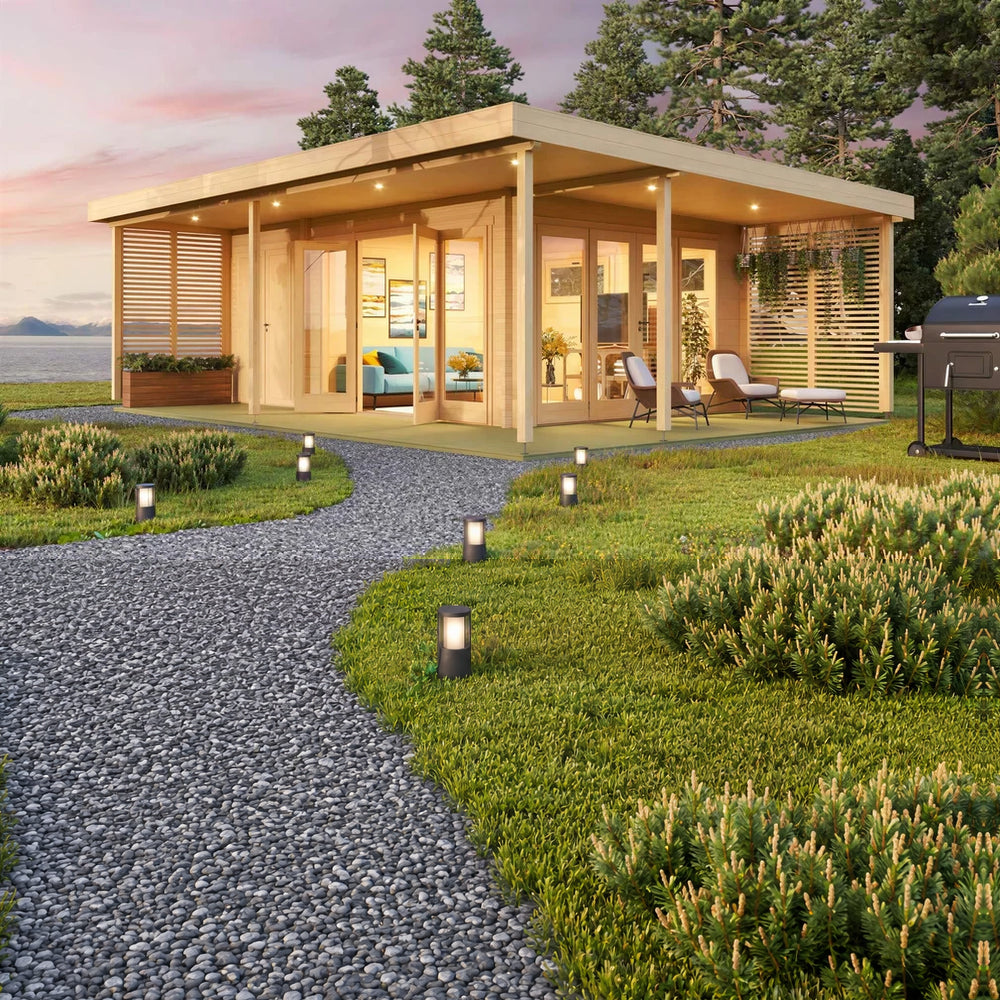 At sunset, the GardenHouse24 USA Kilian 70 Garden Room glows with ambient lighting, outdoor seating, and a cozy furnished interior