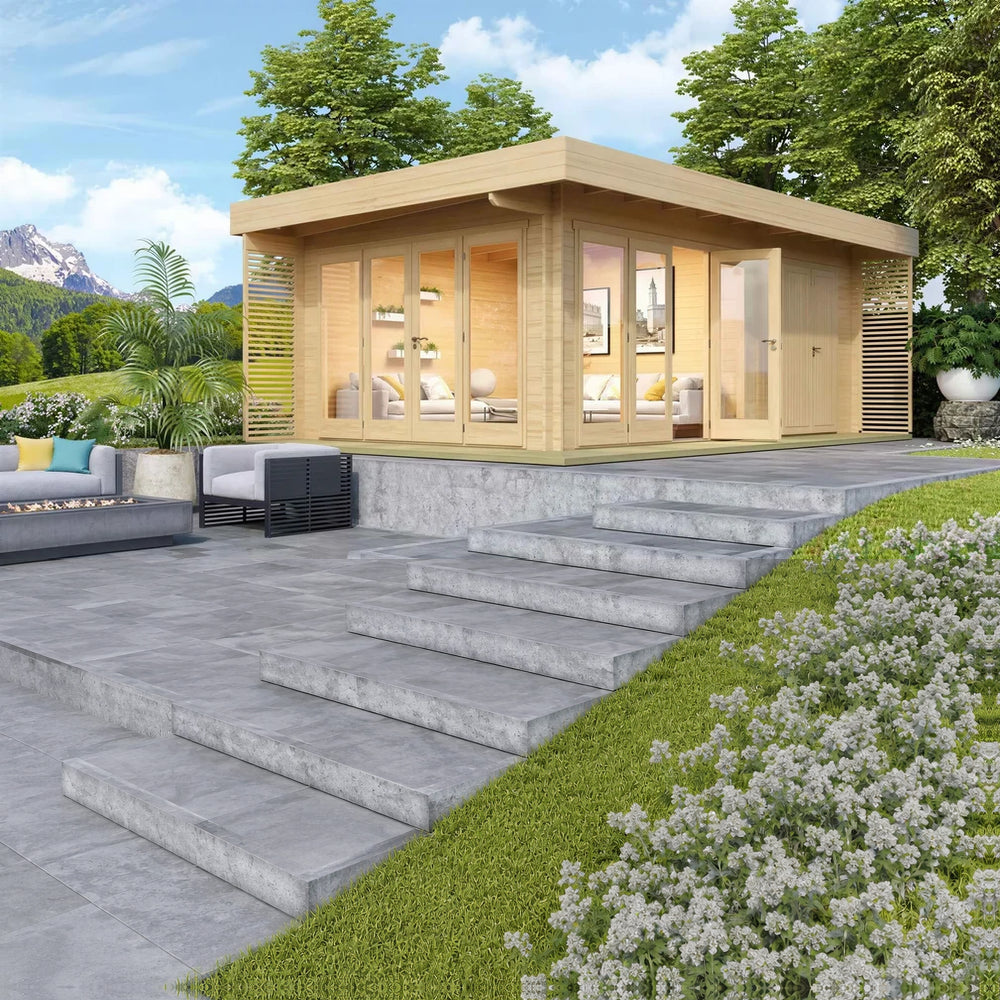 A lifestyle photo of the GardenHouse24 USA Konrad 44 Garden Room shows it placed on a raised patio with lush trees and mountains in the background
