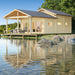 GardenHouse24 USA Lake House 70A Garden Room stands serenely by a lake