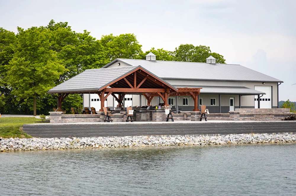 Lakeside view of Brookside Timber Frame Combolan Estate Pavilion presents a picturesque setting with its grand timber design