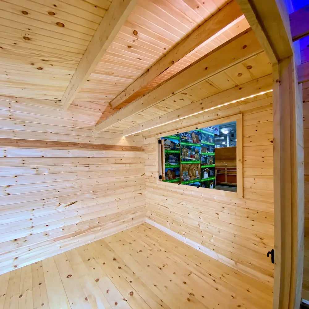 Unfinished pine interior of the Lakeside Versa Cabana 67 with exposed ceiling beams, LED lighting, and a framed serving window.