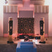 Listening room with speakers and acoustic treatment panels, featuring GIK Acoustics GridFusor™ Diffuser units mounted high on the front wall for sound diffusion