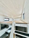 Loft in Sawmill Structures Wanderlove Tiny Home offers a low-ceiling sleeping area with natural light from several windows and a wood-paneled ceiling