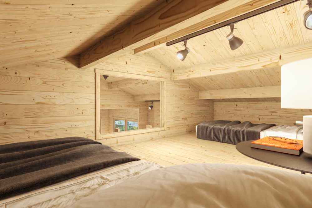 Loft view of the Sawmill Structures Edwin Lake House PLUS 70MM Garden Room reveals multiple sleeping spots under track lights and a wide interior window overlooking the main room