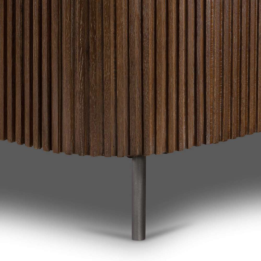 Lower frame of Crate & Barrel Baylor Brown Ribbed Solid Oak Wood Bed displays ribbed solid oak panels supported by a slim dark metal leg