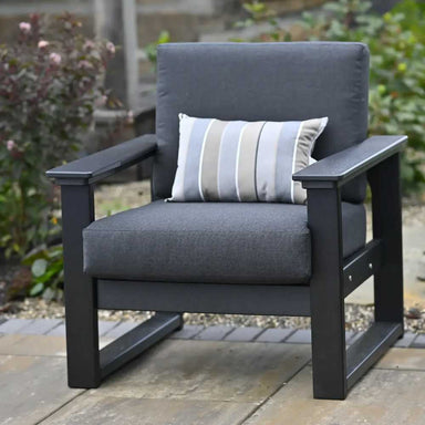 LuxCraft Lanai Deep Seating Chair is shown in a cozy outdoor setting with dark cushions and a striped pillow